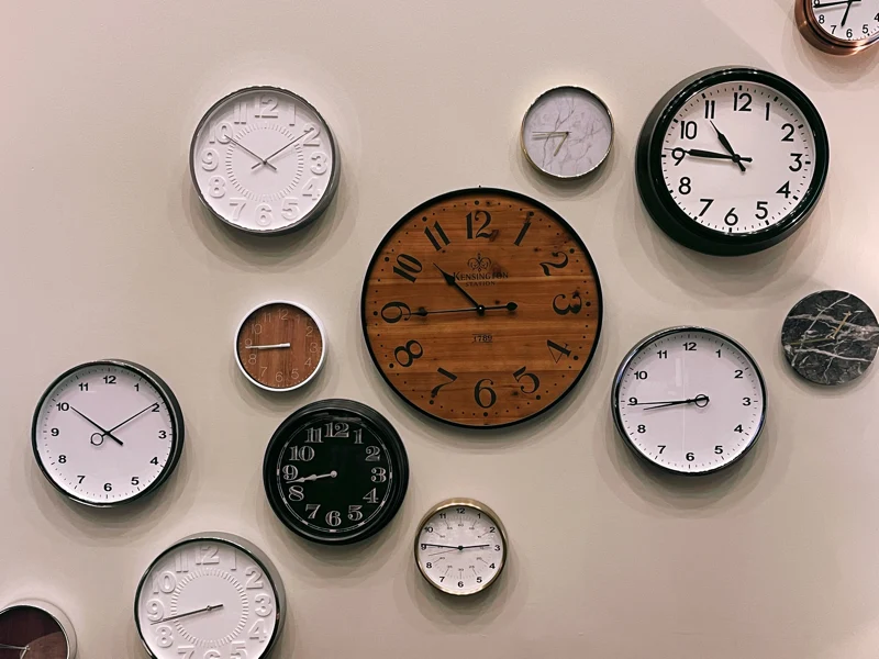 a series of different clocks on a wall