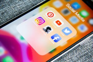 an iPhone shows social media platforms like Twitter, Facebook and Instagram