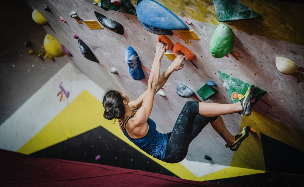 A LinkedIn influencer climbs an indoor rock climbing wall